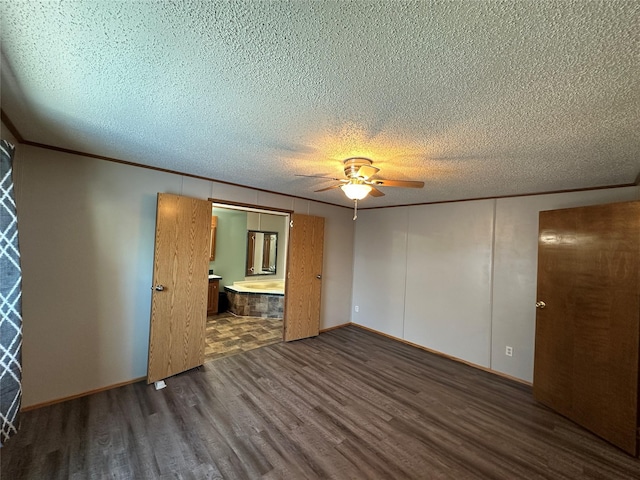 unfurnished bedroom featuring dark wood-type flooring, ceiling fan, ensuite bath, and a textured ceiling