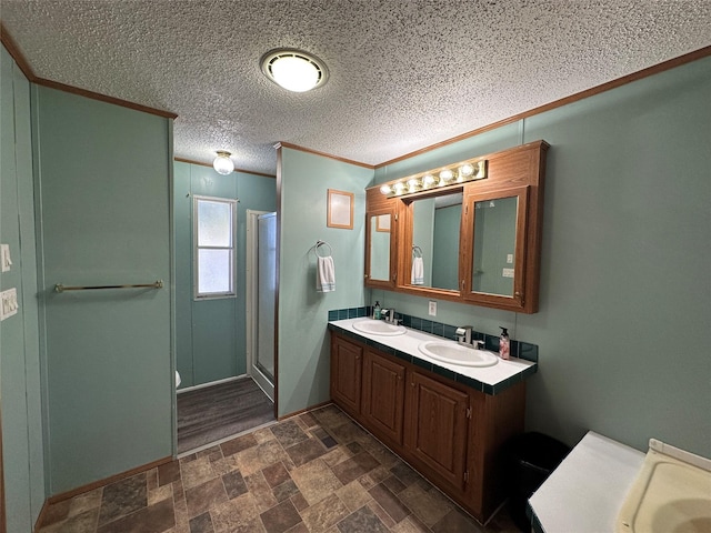 bathroom with vanity, ornamental molding, and a shower with shower door