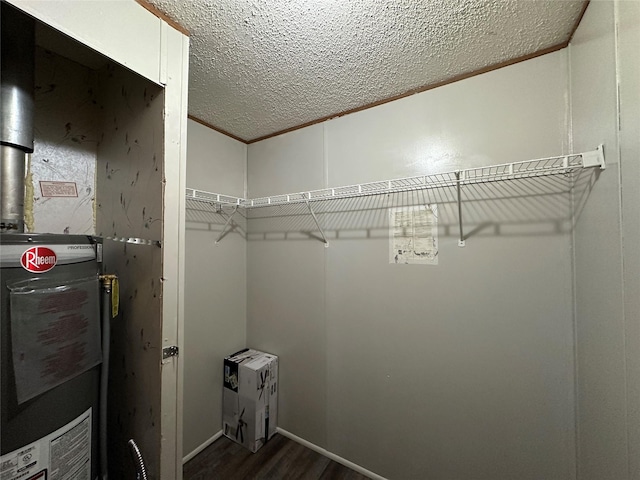 walk in closet with water heater and dark hardwood / wood-style flooring