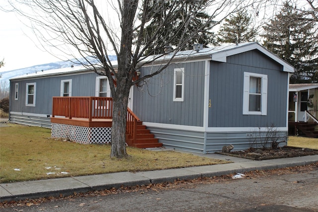 view of front facade featuring a front yard and a wooden deck