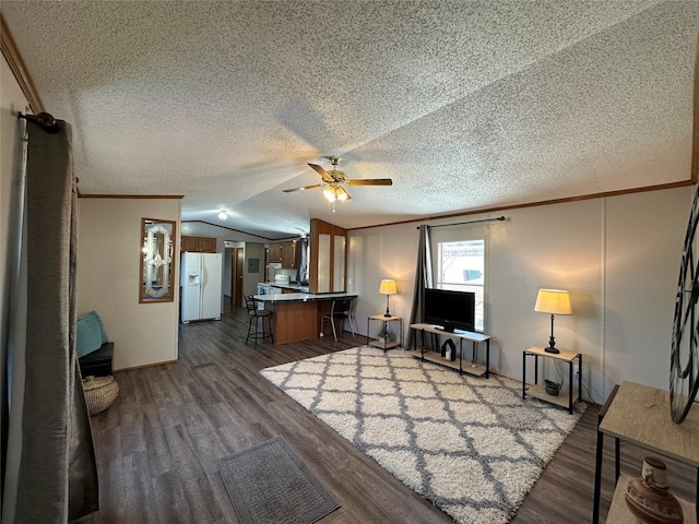 unfurnished living room featuring lofted ceiling, a textured ceiling, ornamental molding, dark hardwood / wood-style flooring, and ceiling fan