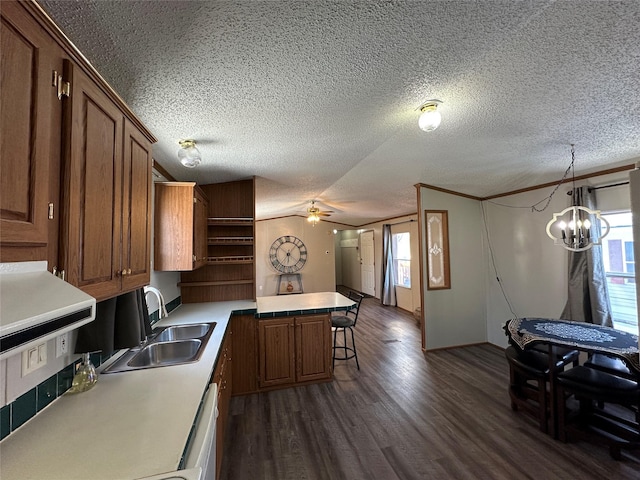 kitchen with a wealth of natural light, decorative light fixtures, sink, a breakfast bar area, and ornamental molding