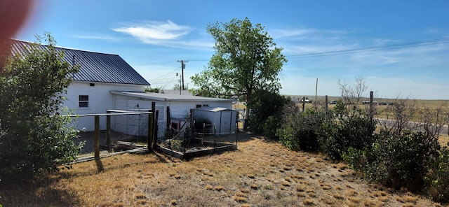 view of yard with an outdoor structure, a storage unit, and fence