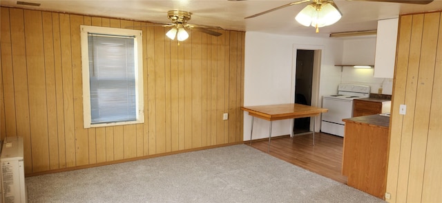 interior space featuring wooden walls, dark countertops, ceiling fan, and white electric range oven