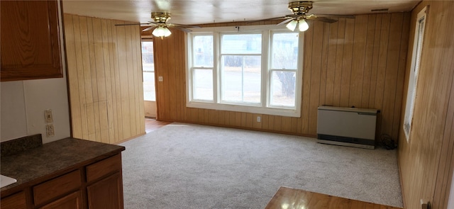 unfurnished room featuring heating unit, light colored carpet, and a healthy amount of sunlight