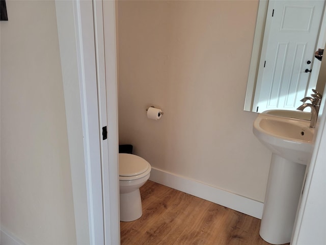 bathroom with hardwood / wood-style floors and toilet