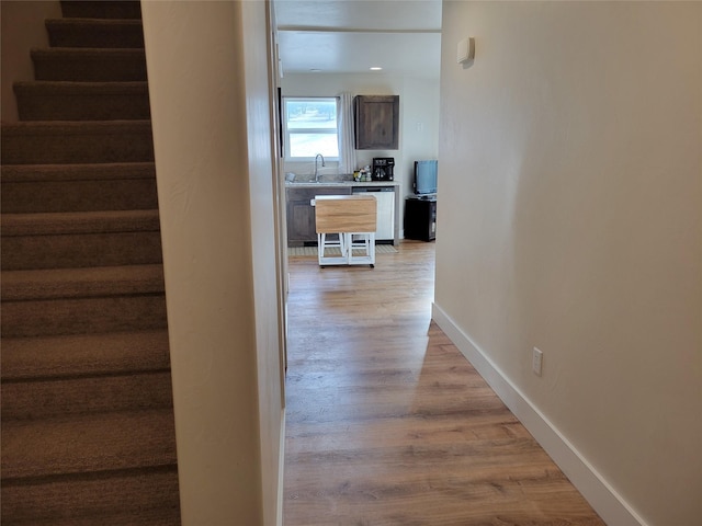 corridor with sink and light hardwood / wood-style floors