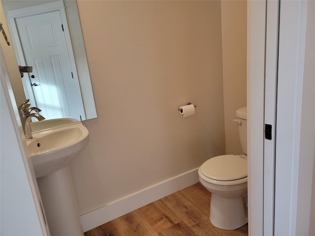 bathroom featuring hardwood / wood-style floors, toilet, and sink