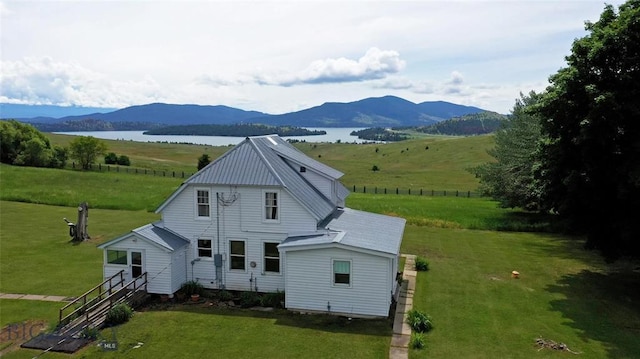 back of house with a lawn and a water and mountain view