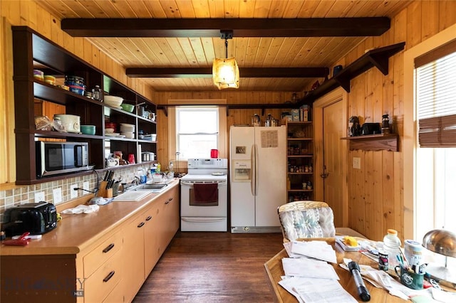 kitchen featuring a healthy amount of sunlight, beamed ceiling, hanging light fixtures, and white appliances