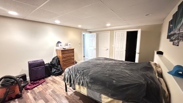 bedroom featuring a paneled ceiling and hardwood / wood-style flooring