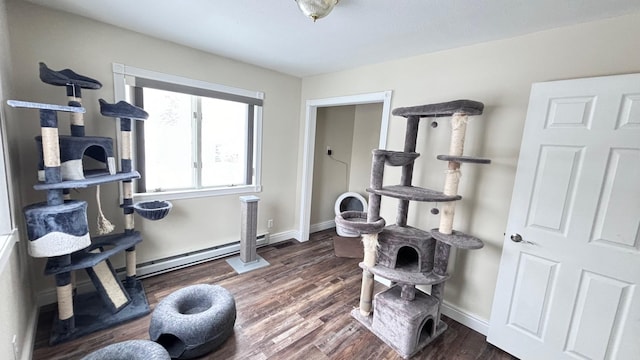 exercise room featuring dark hardwood / wood-style flooring and a baseboard heating unit