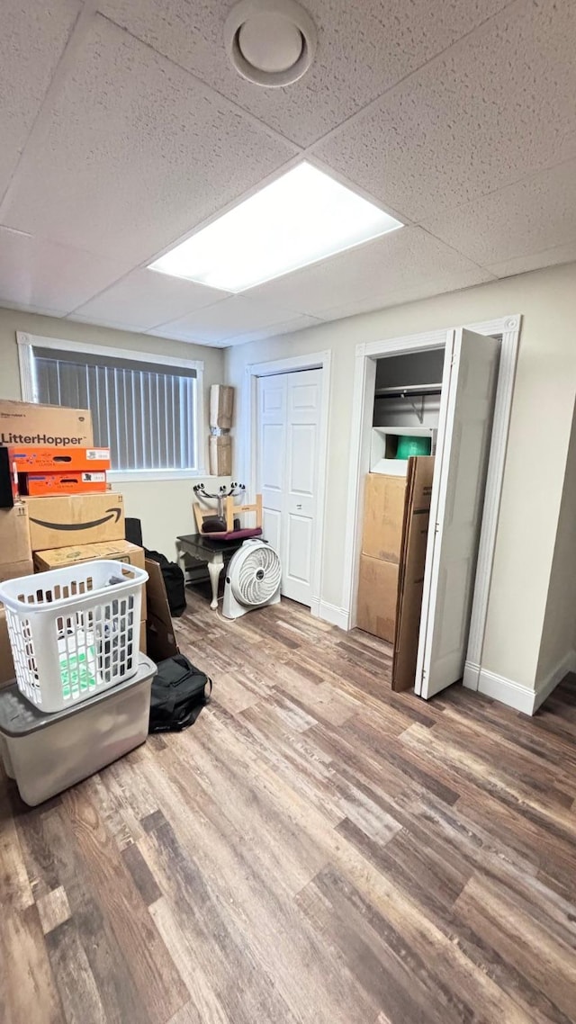 interior space featuring a drop ceiling and hardwood / wood-style floors