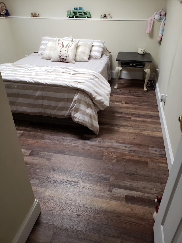 bedroom with dark hardwood / wood-style flooring