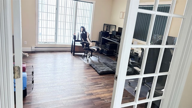 home office with baseboard heating and dark wood-type flooring