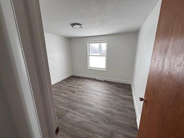 empty room featuring dark hardwood / wood-style flooring