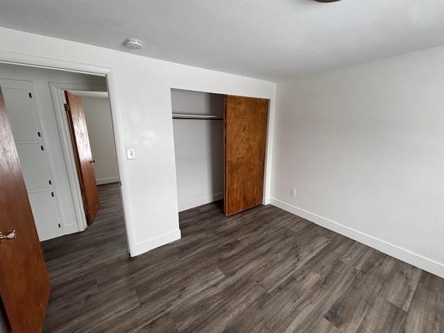 unfurnished bedroom featuring a closet and dark wood-type flooring