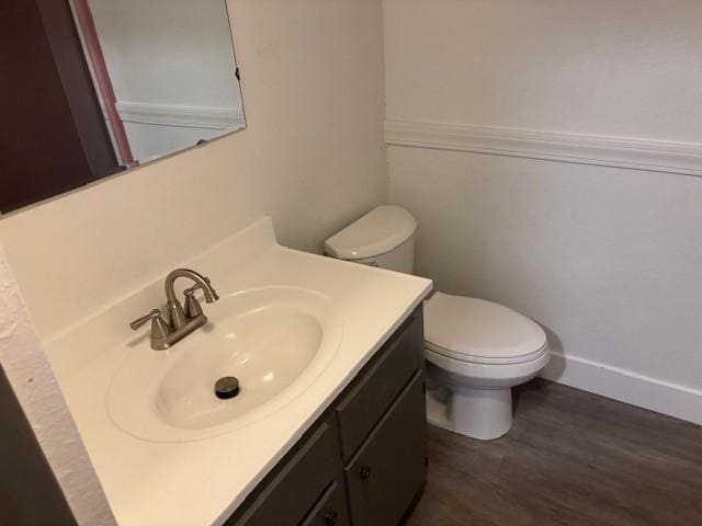 bathroom with hardwood / wood-style floors, vanity, and toilet