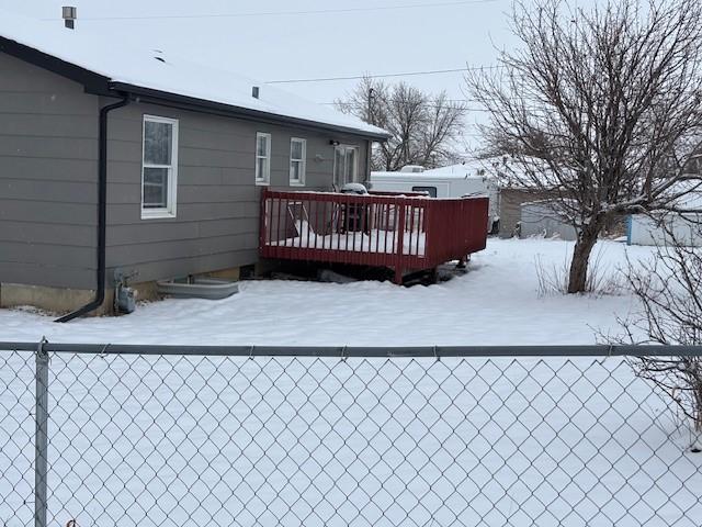 snow covered rear of property featuring a wooden deck