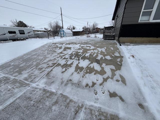 yard covered in snow featuring an outbuilding