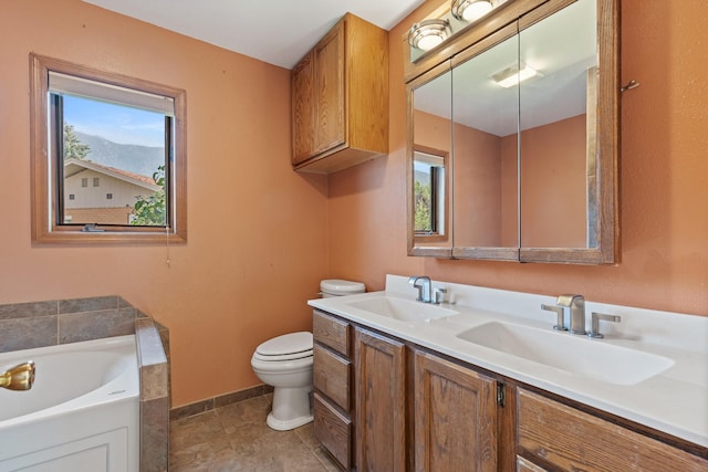 bathroom featuring vanity, toilet, and a tub