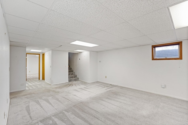 basement with light colored carpet and a drop ceiling