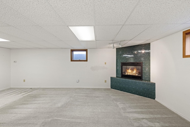 basement with carpet and a tiled fireplace