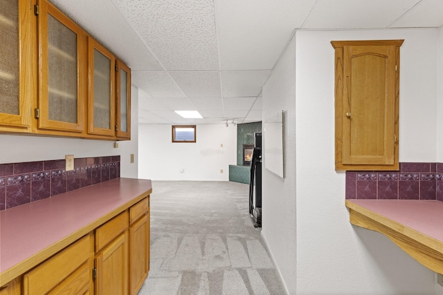 kitchen with light carpet, a large fireplace, and a paneled ceiling