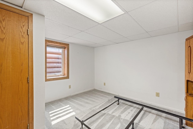 carpeted empty room featuring a paneled ceiling