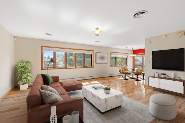 living room with baseboard heating and light hardwood / wood-style flooring