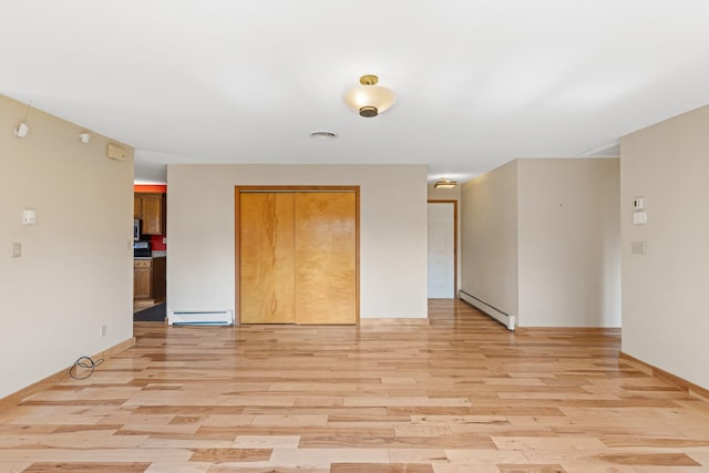 empty room featuring light hardwood / wood-style flooring and a baseboard radiator