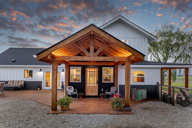 back house at dusk with a wooden deck and an outdoor hangout area