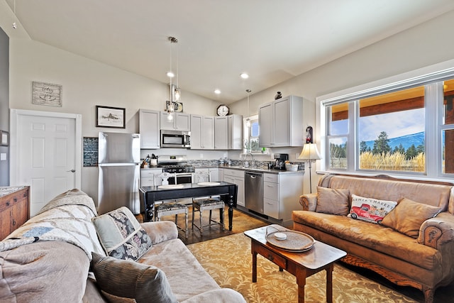 living room featuring hardwood / wood-style flooring, lofted ceiling, and sink