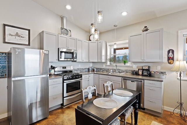 kitchen featuring pendant lighting, sink, stainless steel appliances, and vaulted ceiling