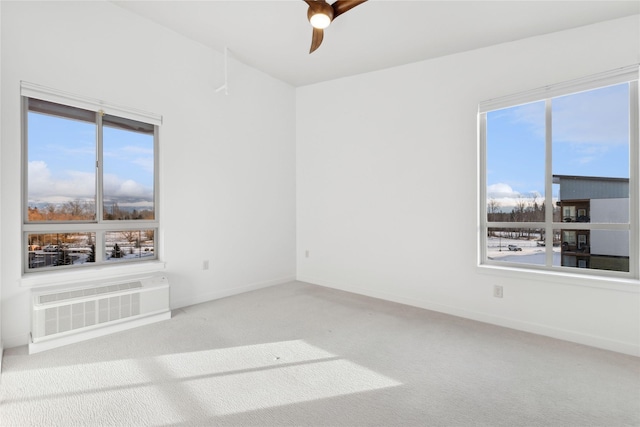 empty room with a wall unit AC, ceiling fan, and carpet floors