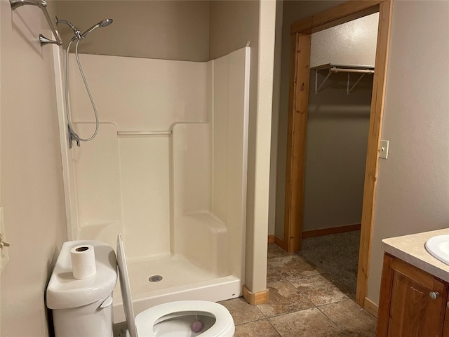 bathroom featuring vanity, toilet, and walk in shower