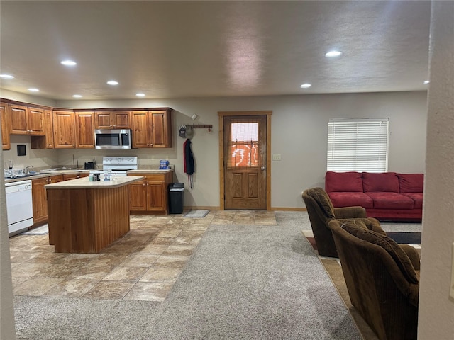 kitchen with a kitchen island, light colored carpet, and white appliances