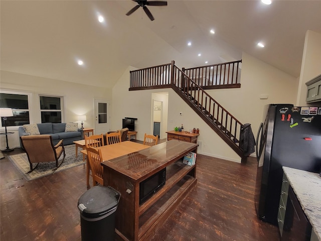 dining room with ceiling fan, dark hardwood / wood-style flooring, and high vaulted ceiling