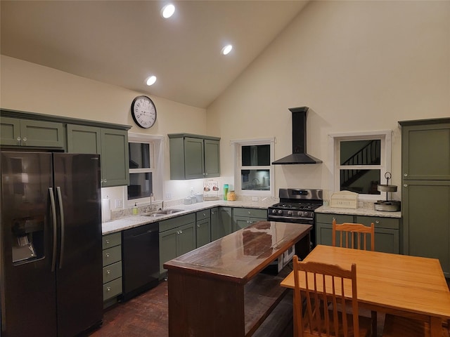 kitchen featuring sink, wall chimney range hood, stainless steel appliances, and green cabinetry