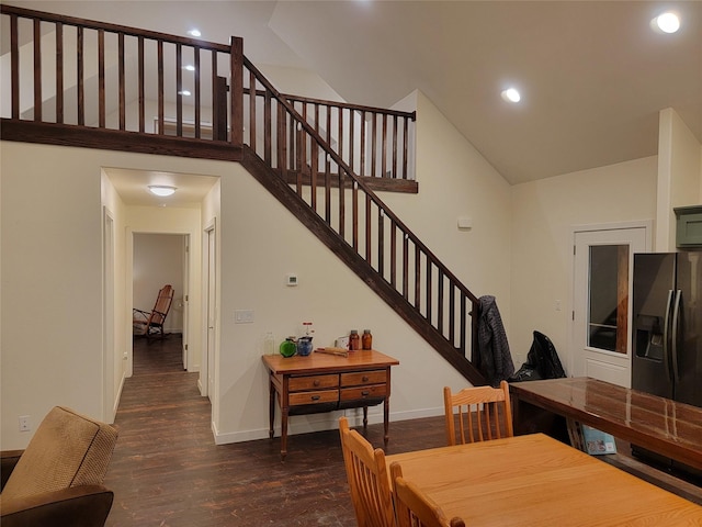 dining space featuring dark hardwood / wood-style flooring and a high ceiling