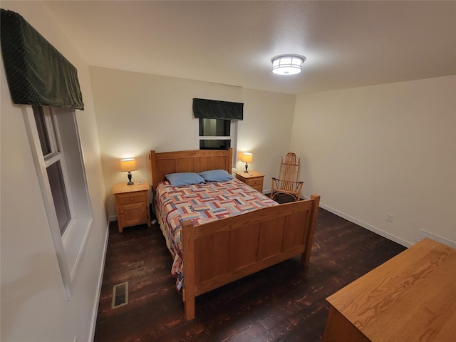 bedroom with dark hardwood / wood-style flooring