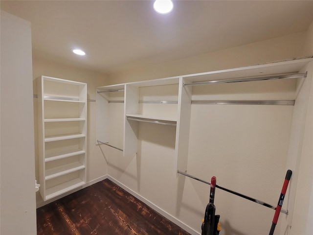 walk in closet with dark wood-type flooring