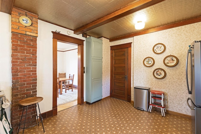 hallway featuring beamed ceiling, light colored carpet, and ornamental molding