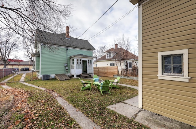 back of property with a lawn and central AC unit