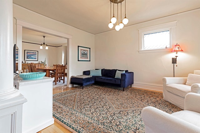 living room featuring ornamental molding, light wood-type flooring, and a notable chandelier