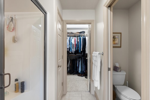 bathroom featuring tile patterned floors, toilet, and walk in shower