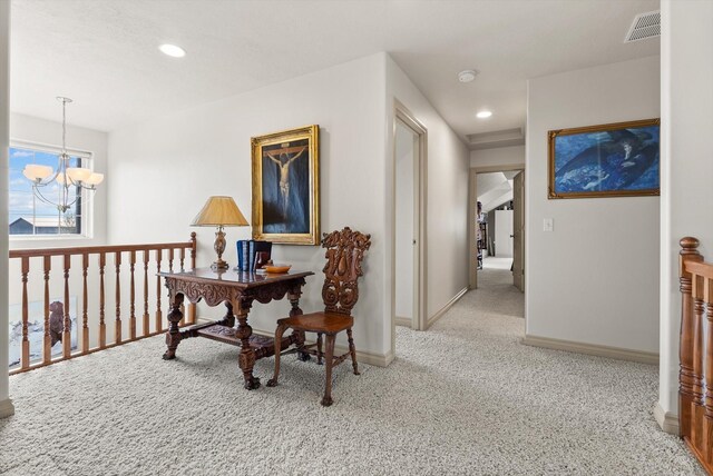 hall with light colored carpet and a chandelier