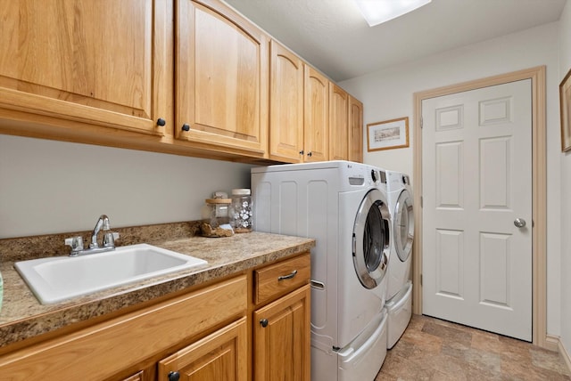 laundry area with washer and dryer, cabinets, and sink