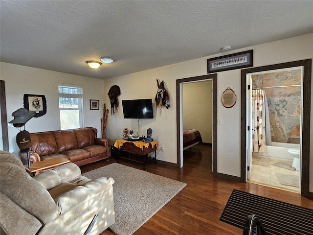 living room with dark hardwood / wood-style flooring and a textured ceiling