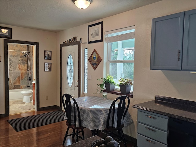 dining area featuring a textured ceiling and dark hardwood / wood-style flooring